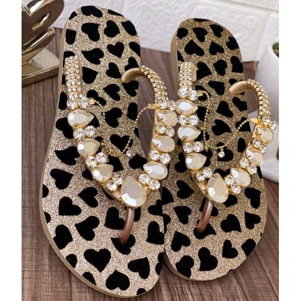 Golden slippers for women with black hearts decorated with stones and a golden accessory